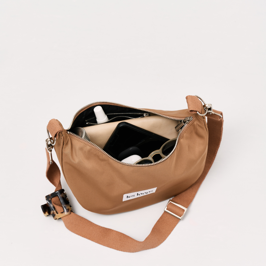 Die halbmondförmige Crossbody Bag Salted Caramel bietet ausreichend Platz für die Wertsachen und ist kompakt