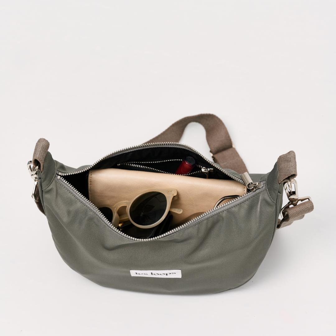 Die halbmondförmige Crossbody Bag in graugrün ist ausreichend groß und dennoch kompakt