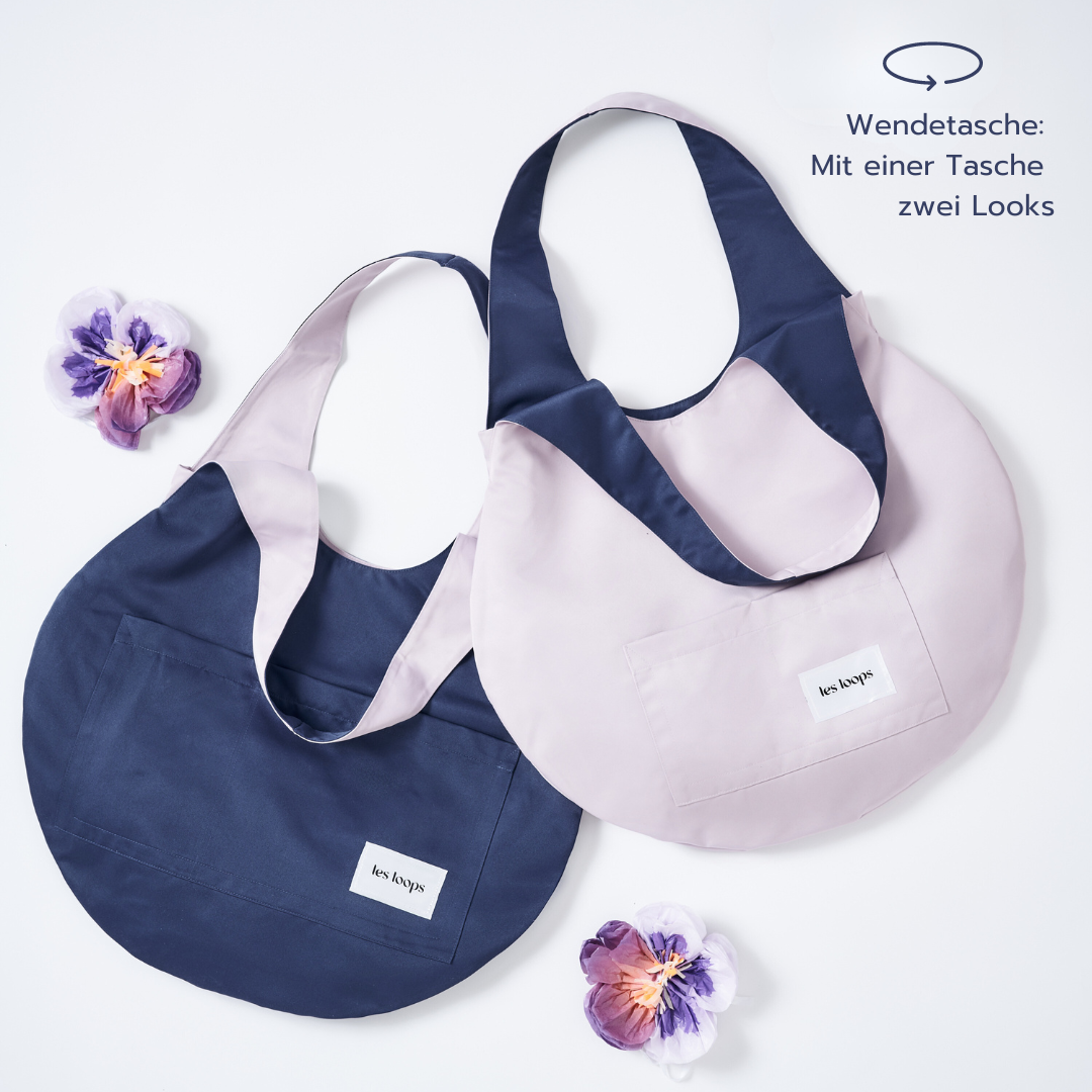 Die Wendetasche Loops Shopper Navy Lavender im Bundle kann wechselseitig in den Farben Navy und Lavendel getragen werden.