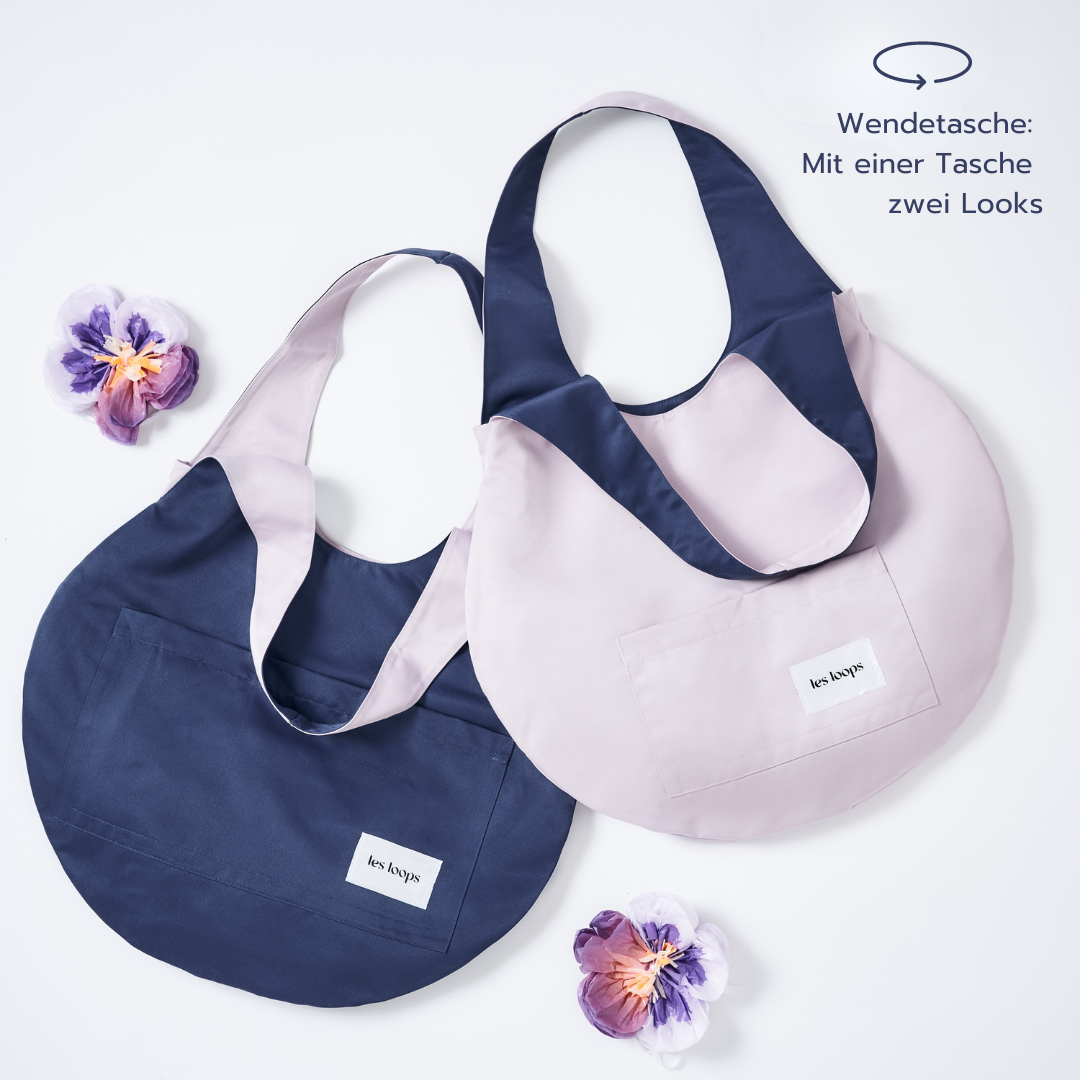 Die Wendetasche Loops Shopper Navy Lavender kann wechselseitig in den Farben Navy und Lavendel getragen werden. 